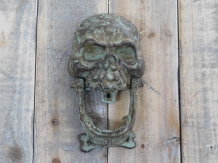 Cast iron green-brown skull as a door knocker.