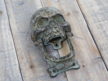 Grün-brauner Totenkopf aus Gusseisen als Türklopfer.