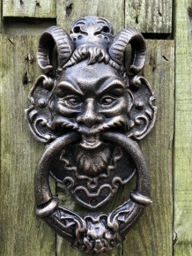 Cast iron bronze door knocker with devil's head.