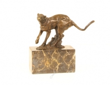 A bronze statue/sculpture of a running puma