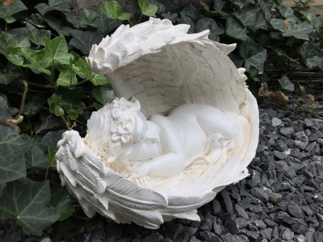 Statue of an angel sleeping in his wings, made of polystone