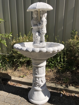 Garden fountain full of stone with children under an umbrella, great!