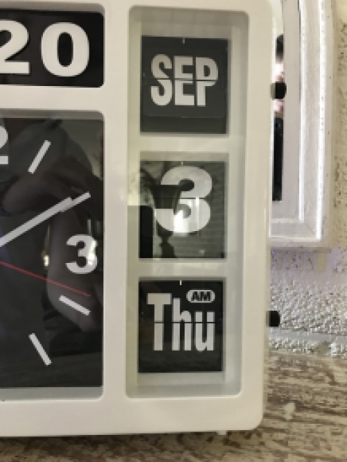 A clock with year, date and time, with stand, but can also hang on the wall, white