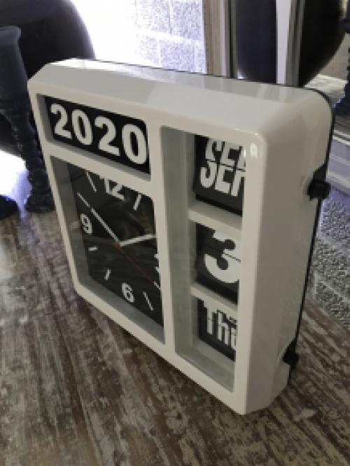 A clock with year, date and time, with stand, but can also hang on the wall, white