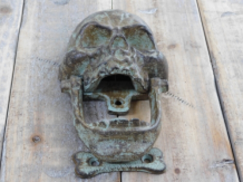 Cast iron green-brown skull as a door knocker.