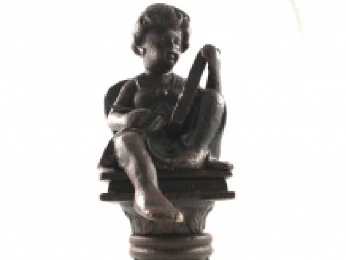 Intact statue of an angel sitting on a pedestal writing, cast iron