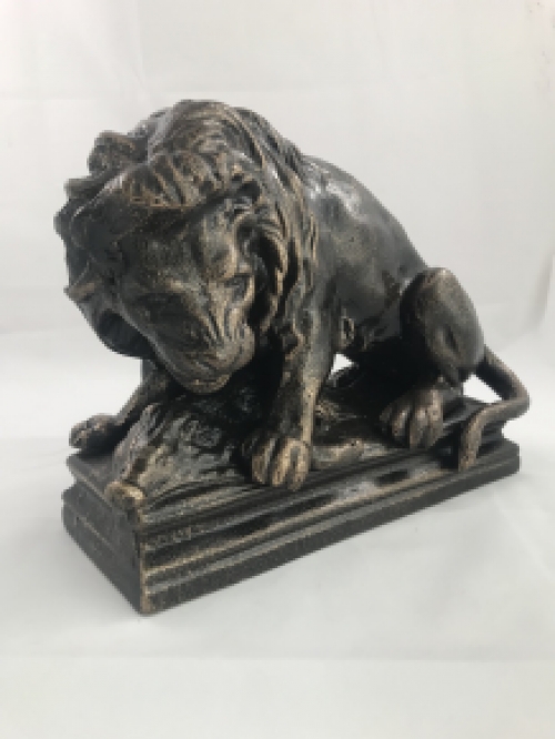 A beautiful statue of a lion with its prey, a boar, made of cast iron, bronze look!