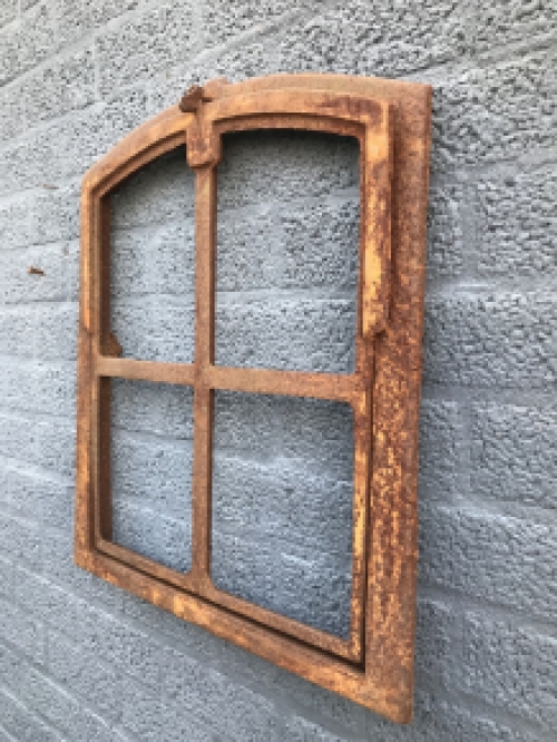 An antique-looking stable window, foldable open, untreated cast iron, resting surface, window