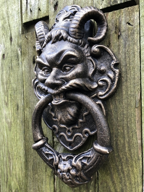 Cast iron bronze door knocker with devil's head.