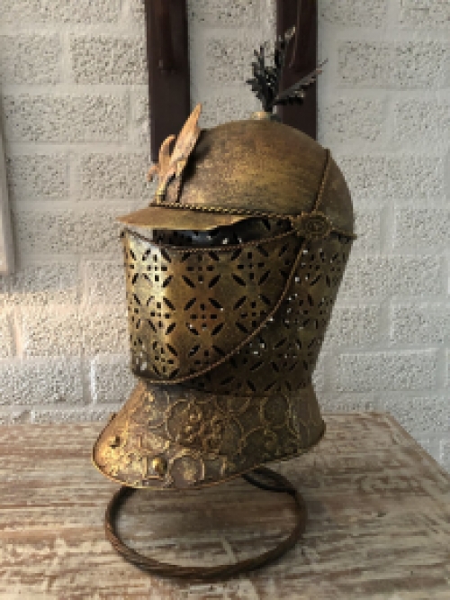 Ein schöner Ritterhelm aus Messing auf einem Ständer.