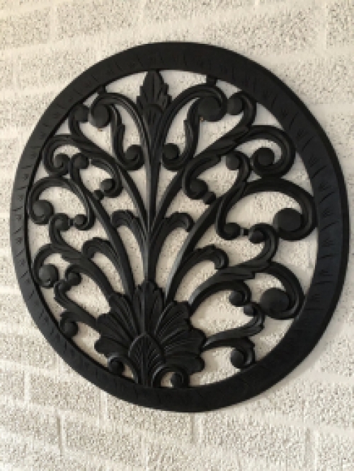 Wall ornament round, decoratively carved, black-brown.