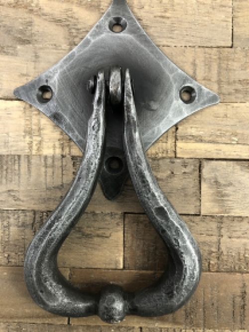 Beautiful design is this door knocker wrought iron for on the rustic wooden door.