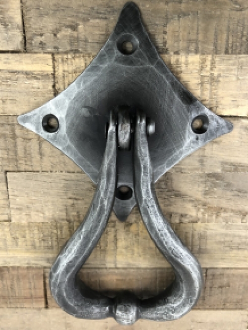 Beautiful design is this door knocker wrought iron for on the rustic wooden door.