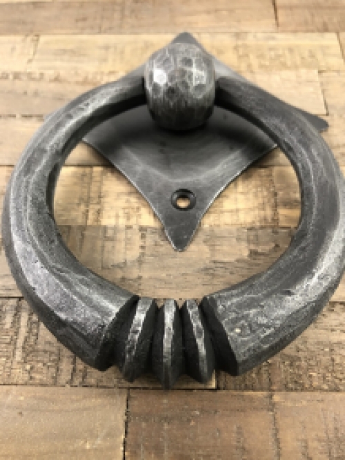 Pull-ring - door knocker wrought iron for on the rustic wooden door, convent door, country house door.