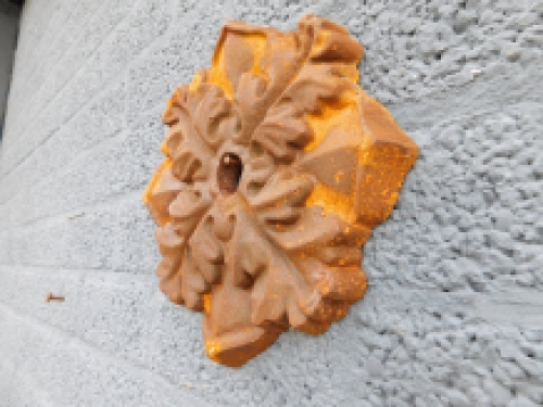 Wall anchor, cast iron, rust brown, leaf shape.