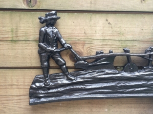 Wall decoration , cast iron black fireplace plate farmer with horse and plow.